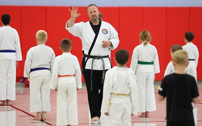 Officer Roy W. Tittle, of the Alliance Police Department, works with children he teaches martial arts to.