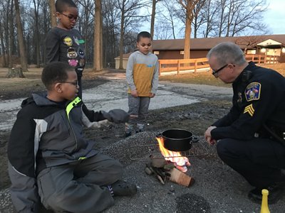 At one of the first Cop Scouts meetings, Sgt. Todd Leisure showed kids how to make pop can stoves, which they used to make hot chocolate. Photo courtesy of Richmond Heights Police Department